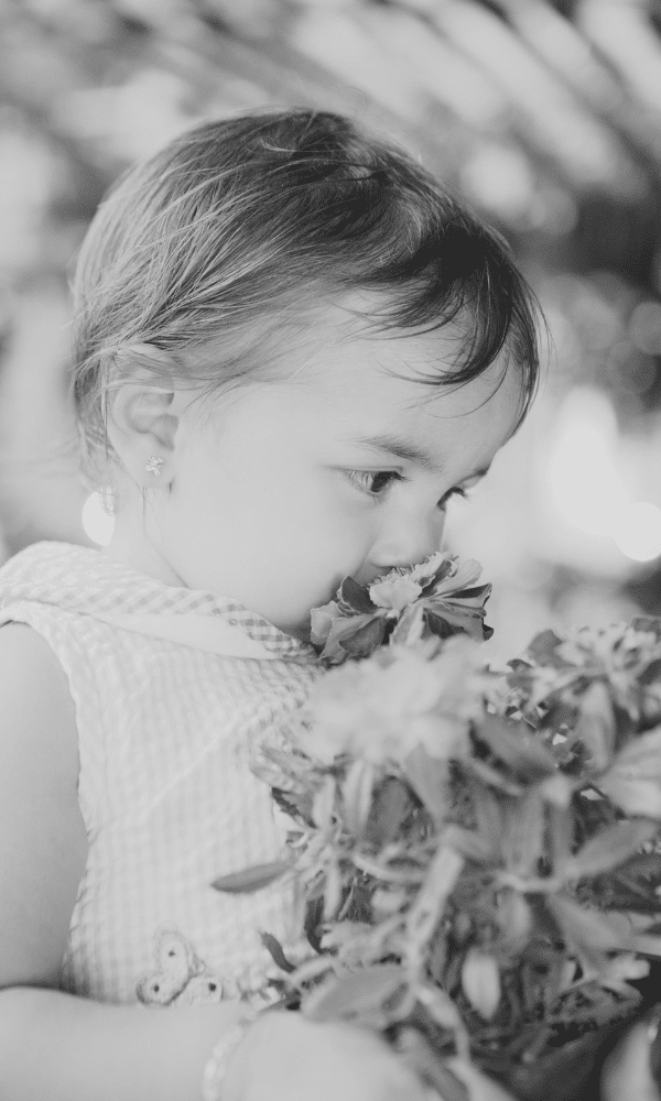 Toddler smelling flowers